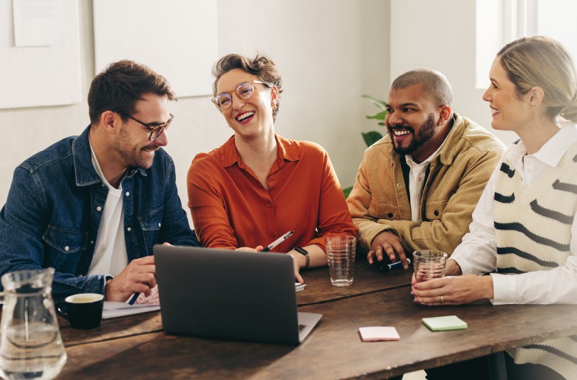 Employees sitting at a table discussing 2024 wellbeing trends